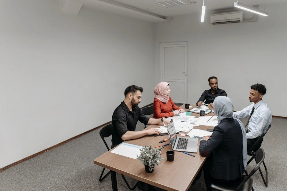 A diverse group of professionals collaborating around a table in a modern office.